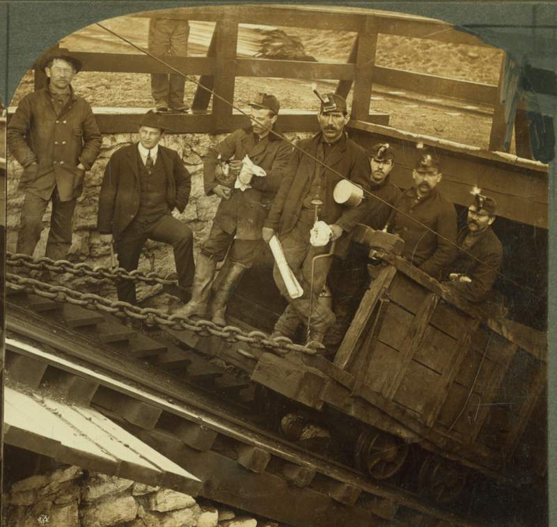 an old photograph of miners in a minecar